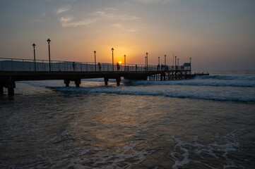 Fototapeta na wymiar Pier in the sea with sun rising from the sea.