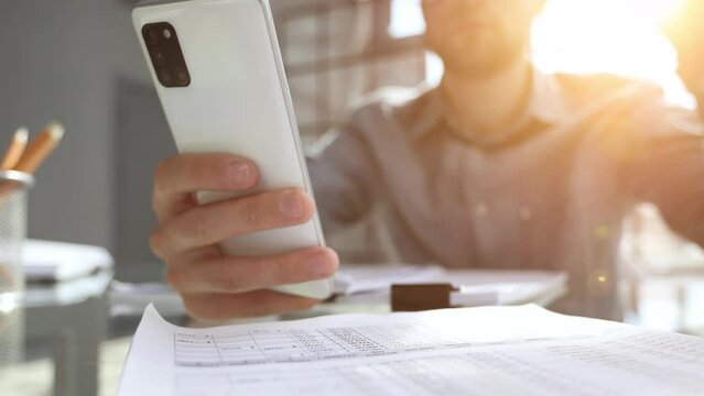 uses smrt phone for making calls or reading news online. Businessman reviews documents