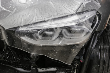A car wrapping specialist applies a polyurethane film to the car. Selective focus. PPF protective...