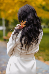 Girl in a white coat in an autumn park