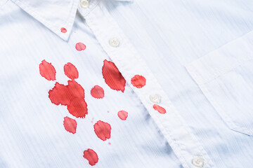 A drops of blood a white shirt. Stained clothing. daily life stain concept. Cleaning concept. top...