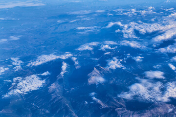 Mountain peaks seen through the clouds from the plane