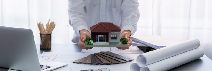 Interior architect designer at workstation table designing house interior blueprint and choosing...