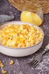 Bowl of tasty Italian pasta with Cheddar cheese on grunge background
