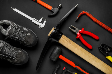 Set of construction tools and shoes on black background