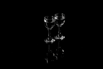 Shots of cold vodka on black background