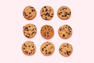 Tasty cookies with chocolate chips on pink background