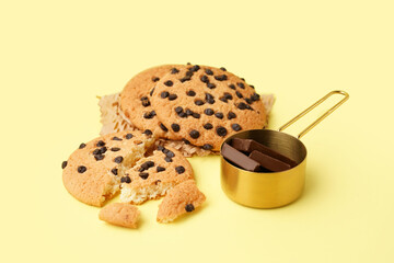 Tasty cookies with chocolate chips on yellow background