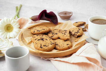 Plate of tasty cookies with chocolate chips on white background