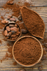 Bowls with cocoa powder and beans on wooden background