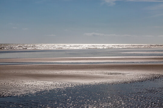 Low Tide At Winchelsea Beach On The Sussex Coast, With A Blue Sky Overhead