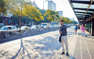 latina american man commuter looking at the time waiting for transportation in downtown 