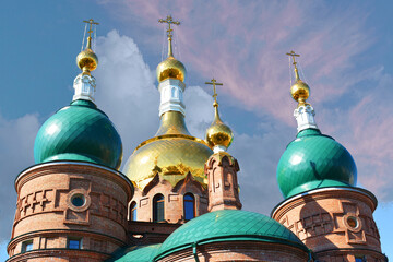 Three domes with crosses of the Orthodox Church, blue sky.
