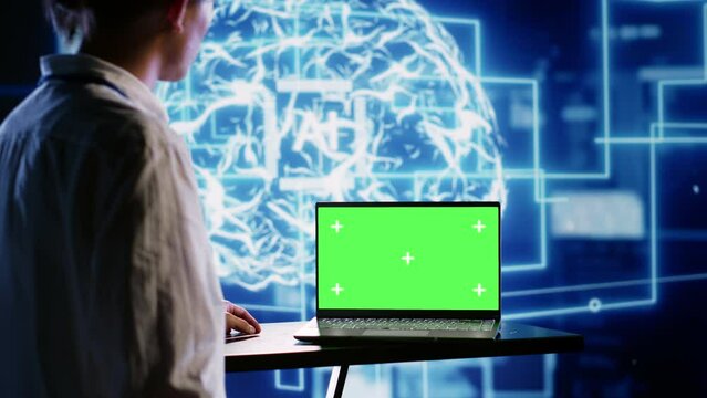 Proficient worker using green screen laptop to implement artificial intelligence parallel processing. Tech support man works on chroma key device enabling AI systems to do machine learning inference