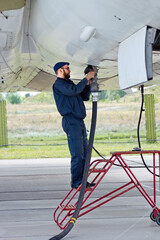 Fototapeta na wymiar Aviation technician refueling of airplane at airport