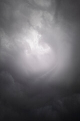 Stormy sky cloudscape with a round bright vortex in the middle