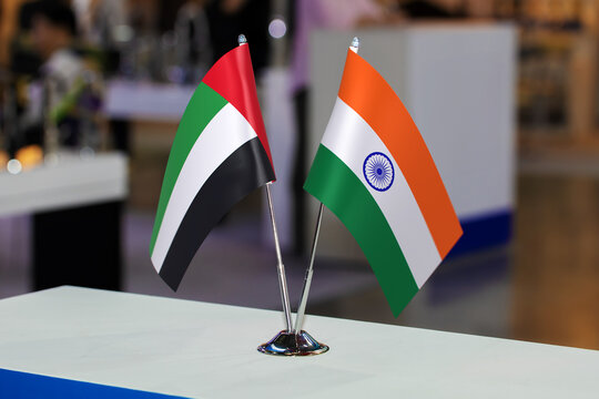 Two small table flags of the United Arab Emirates and India together at some event. Flags of the two countries as a symbol of cooperation between the two states. Joint business of India and the UAE