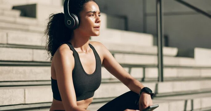 Headphones, woman and phone on stairs for workout break, motivation, exercise music and calm mindset. Wellness, athlete and smartphone for listening to audio for training and running with relax