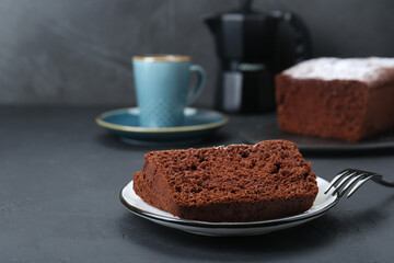 Pieces of tasty chocolate sponge cake on black table