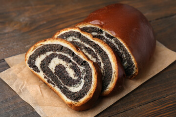 Cut poppy seed roll on wooden table, closeup. Tasty cake
