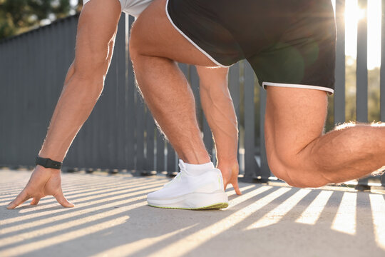 Runner on starting position outdoors on sunny day, closeup
