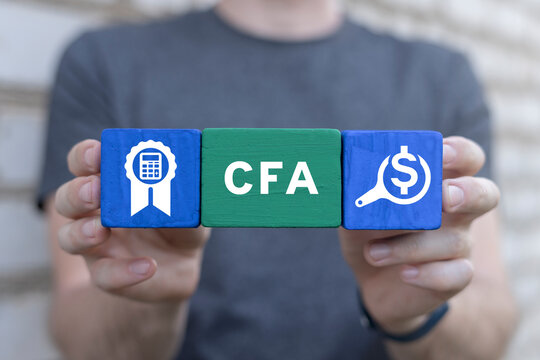 Man holding colorful blocks sees abbreviation: CFA. CFA Chartered Financial Analyst business concept. Program is a postgraduate professional certification.