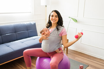 Happy fit mom smiling working out taking care of her baby