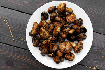 Grilled champignon mushrooms on a round plate.