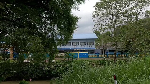 Driving along road in Makassar Sulawesi Indonesia showing pollution in canal