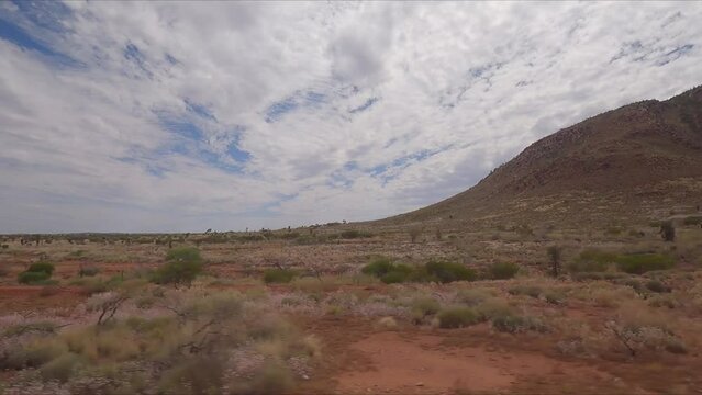 Traveling along Western Australia highway past small red hilly outcrops