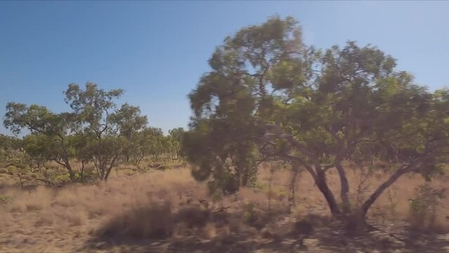 Driving by red rocky geological formations in Western Australia