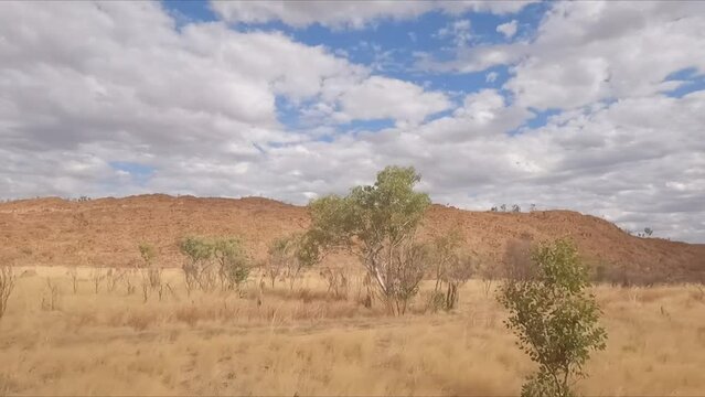 Red dry rock ranges on horizon while driving north from Perth along Western Australian coastal highway