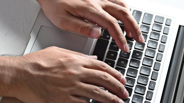 Closeup of a man's hand typing on a computer No face