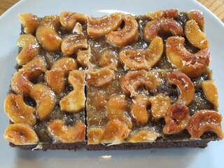 Brownie toffee cake decorated with halved cashew nuts.
