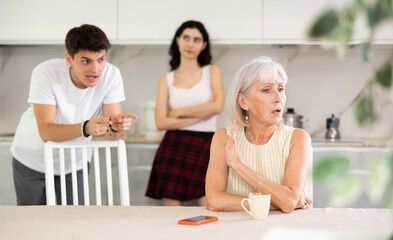 Portrait of thoughtful elderly woman who had conflict with adult children while cooking dinner in...