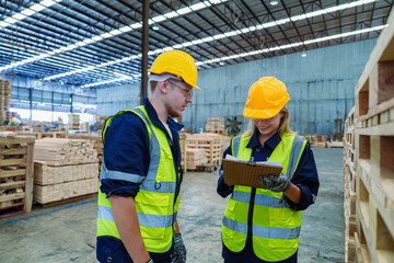Factory engineer staff worker operate machine and hard hat working holding clipboard checking quality of wooden at production line. Production line of the wooden working industrial factory