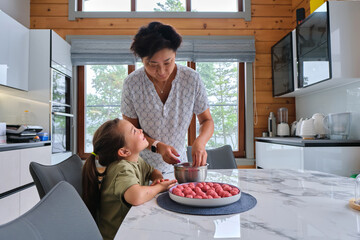 Grandmother and granddaughter preparing meatballs.