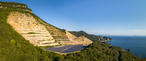 Exposed rock and solar panels at mountain quarry on Shodoshima coast