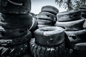 old used car tire stack pile. Piles of used tires from cars and trucks drill holes for use at docks.