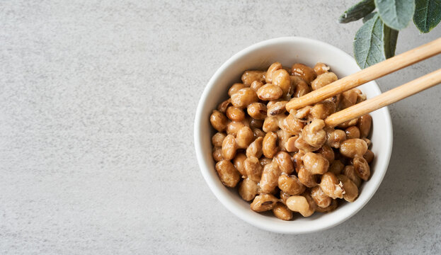 flat lay top view overhead natto or fermented soybean in bowl and chopsticks on table white background. natto or fermented soybean Japanese food. natto ferment soybean white background