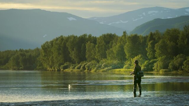 Fisherman fishing in mountain river fjord, amazing landscape at sunrise, wide angle view