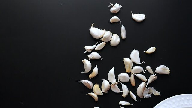  slow motion of garlic fallen on black background 