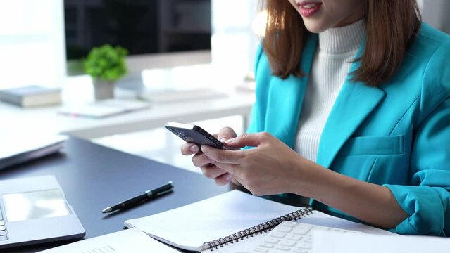 Attractive Asian businesswoman Use your laptop to watch your computer and talk on the phon. Consult customers, sit at a table. financial officer making a mobile business call Discuss work with clients