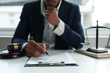 Young lawyer or legal advisor is reading and carefully checking the validity of documents and investment agreements for signing contracts managing justice concepts.