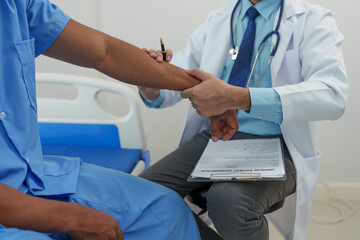 A male doctor is holding his wrist to measure his heartbeat. Pain in the arm muscles of male patients for diagnosis and treatment planning. Providing disease control drugs medical service concept.