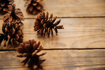 Background with pine cones on a dark wooden board. Christmas, New Year's composition with a place to copy the text.View from above.