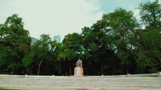 beautiful aerial of Abraham Lincoln monument in Chicago downtown, Illinois. Surrounded by trees in Grant Park. slow orbiting cinematic Aerial. Low angle.
