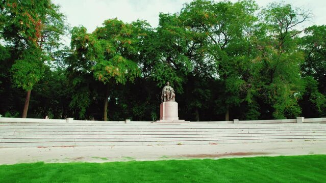 beautiful aerial of Abraham Lincoln monument in Chicago downtown, Illinois. Surrounded by trees in Grant Park. orbiting cinematic Aerial. Low angle, grass in front.