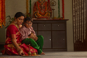 Fototapeta na wymiar Mother and son doing preparation for prayer on Ganesh Chaturthi