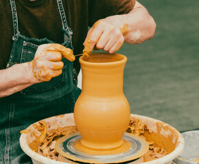 Clay craftsman sculpts crockery . Close-up.